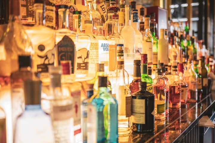 A close-up of various alcoholic beverage bottles displayed on a bar counter.