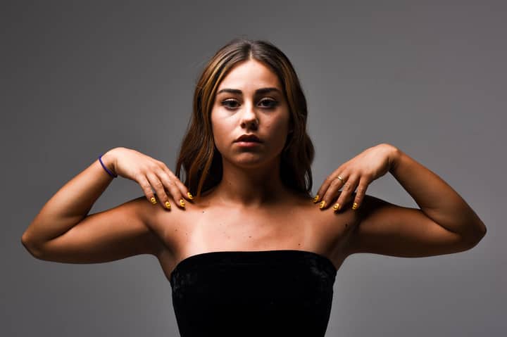A captivating studio portrait of a young woman with elegant pose and neutral background.
