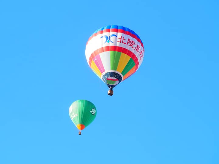 Vibrant hot air balloons floating gracefully in a clear blue sky, capturing a scenic flight moment.