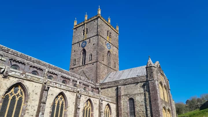 Low-angle view of St Davids Cathedral against clear blue sky in Wales.