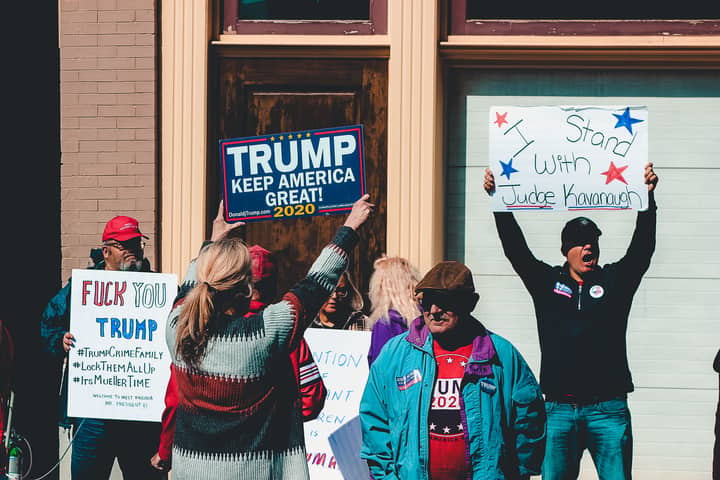 A group of people at a political rally in Wheeling, West Virginia, supporting different 2020 election campaigns.