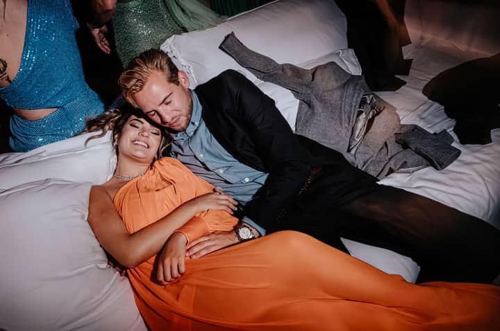 A couple comfortably relaxed at an elegant evening event, showcasing affection and style.
