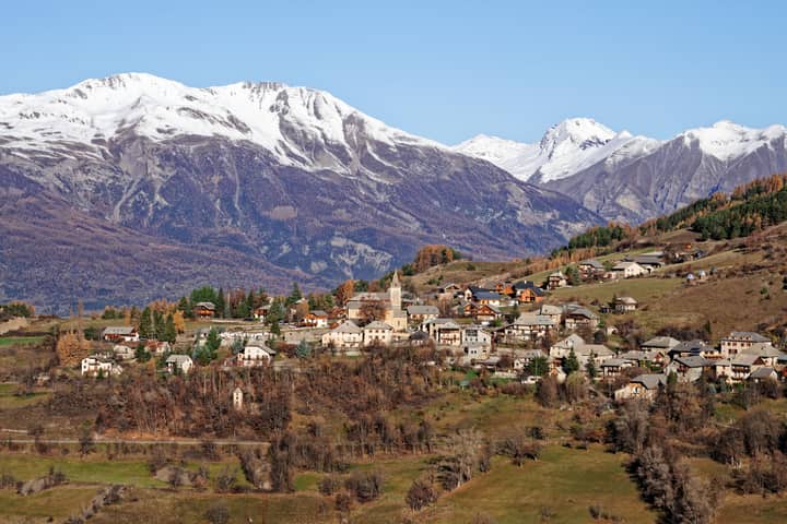 Charming village nestled in the Alps with stunning mountain backdrop in Provence, France.