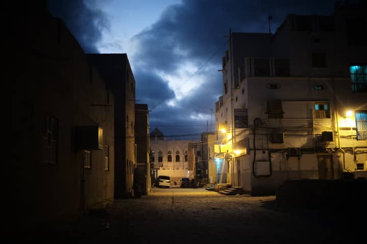 Peaceful evening street scene in Tarim, showing traditional architecture under a cloudy sky.