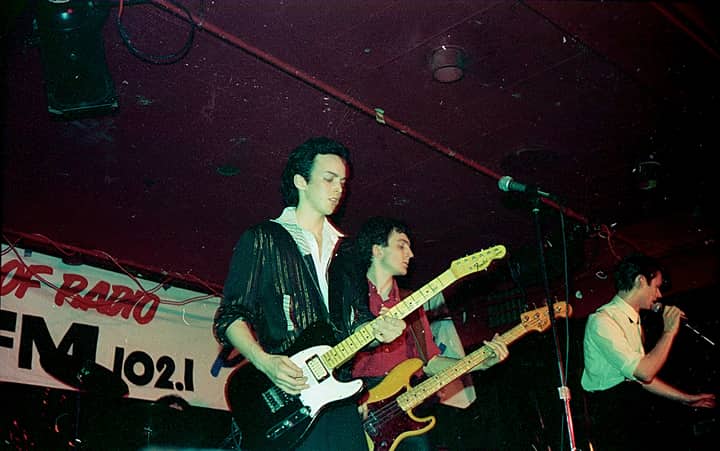 Energetic live performance by musicians playing guitars at an indoor concert.