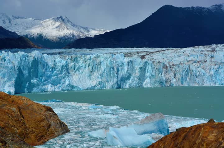 Breathtaking view of Perito Moreno Glacier with icy waters and mountain backdrop in El Chalten, Argentina.