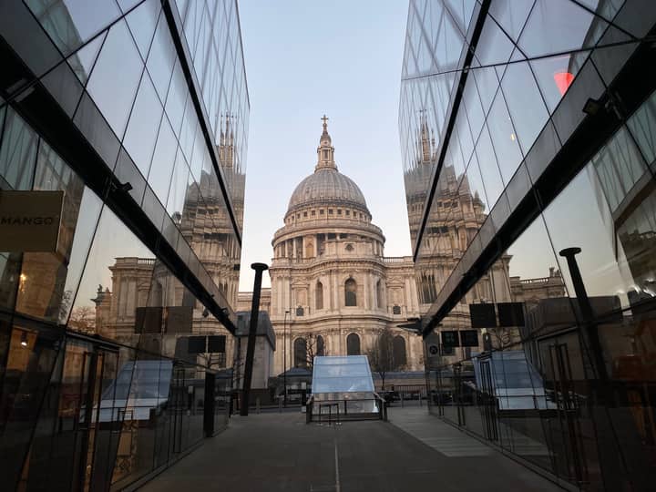 A stunning view of St. Paul's Cathedral framed by modern glass buildings in London.