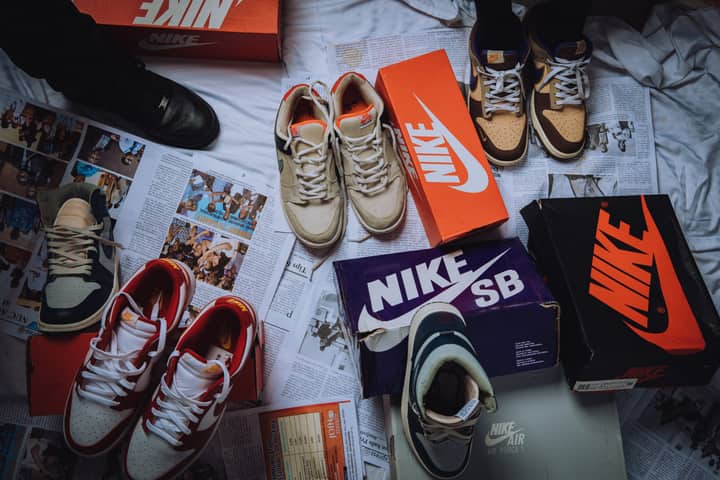 A variety of Nike sneakers displayed on newspapers with branded shoeboxes.
