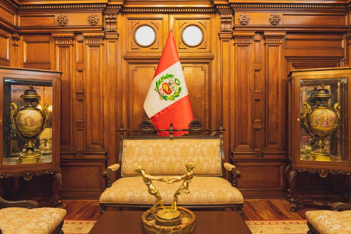 Stylish interior in Lima featuring ornate furniture and the Peruvian flag.