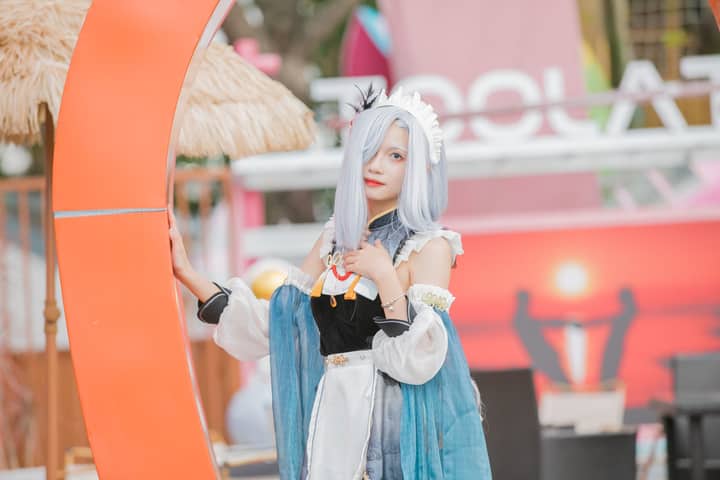 Teenager in elaborate cosplay costume posing outdoors with colorful backdrop.
