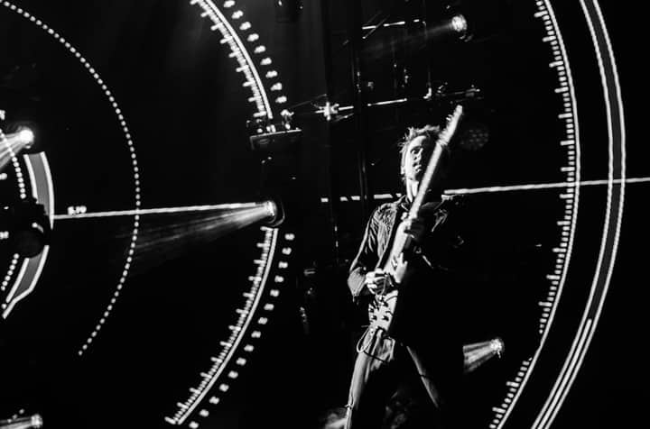 Powerful shot of guitarist on stage amidst stunning light effects at a live music concert.