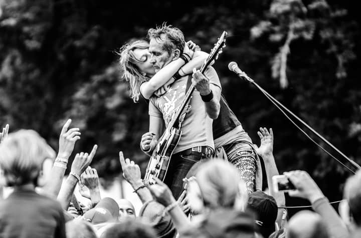 Energetic live music performance with crowd interaction at a rock concert.