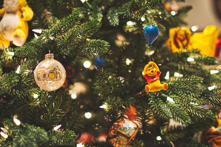 Festive Christmas tree decorated with Winnie the Pooh ornaments and lights.