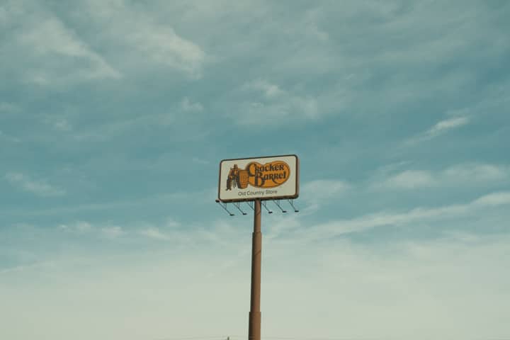 Cracker Barrel signpost with a clear blue sky background in Valdosta, GA, USA.