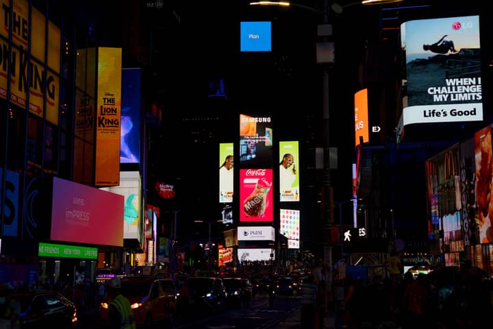 Bright billboards and street life in Times Square, New York City at night.