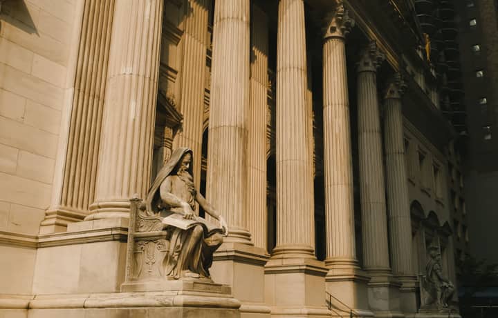 A striking architectural scene featuring classical columns and a detailed sculpture in New York City.