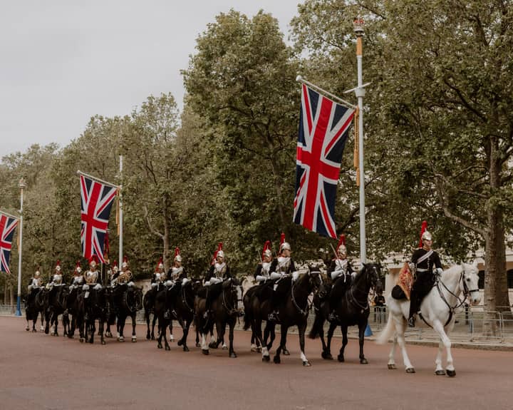 Ceremonial cavalry with Union Flags in a historical parade on The Mall, London.