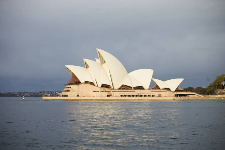 Iconic Sydney Opera House with overcast sky, a top travel destination in Australia.