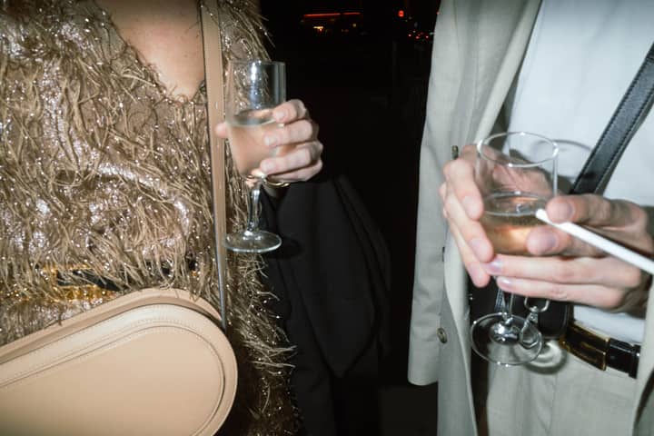 A stylish couple toasting with champagne under city lights during a festive evening celebration.