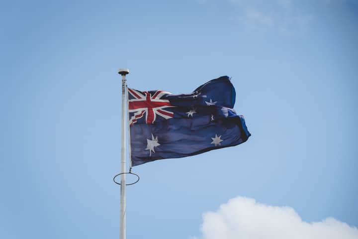 Australian national flag waving on a flagpole against a clear blue sky in Perth.