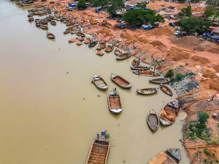 Aerial view of wooden boats along the Niger River in Bamako, Mali. Busy riverbank activity.