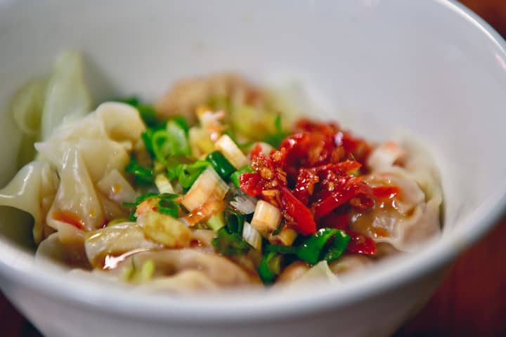 Delicious Taiwanese dumplings garnished with fresh chili and scallions, capturing authentic Asian flavors.