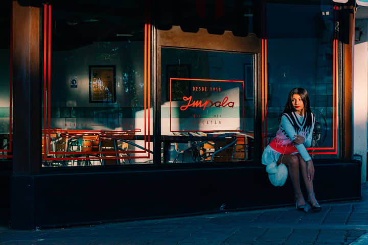 Stylish woman sitting outside a café in evening sunlight.