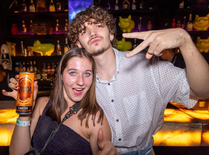 Young adults enjoying a vibrant night out, capturing moments of fun and freedom in a lively bar atmosphere.