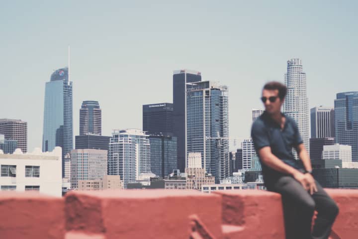 A creatively blurred portrait of a man with Los Angeles city skyline in the backdrop, showcasing urban life.