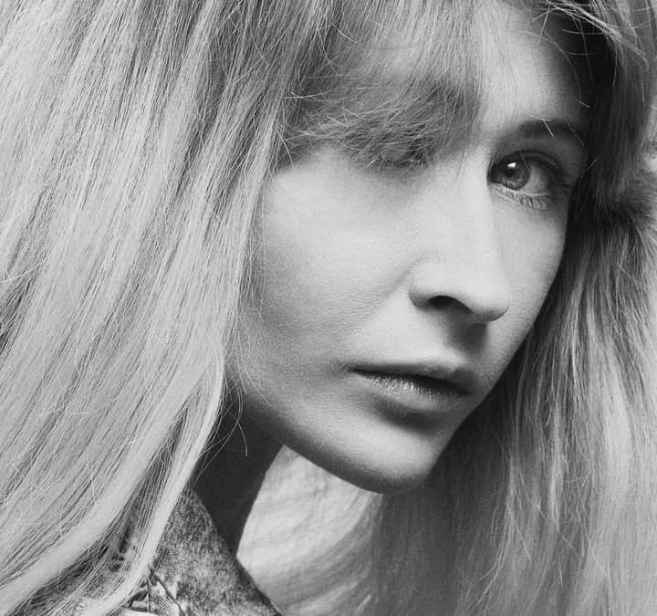 Close-up black and white portrait showcasing a woman's expressive gaze.