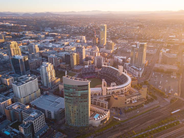 Aerial view of downtown San Diego featuring Petco Park and surrounding cityscape at sunset.