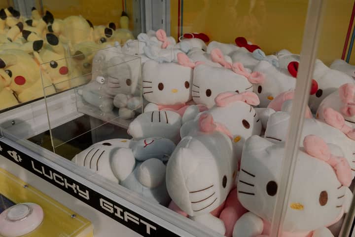Claw machine featuring plush Hello Kitty and Pikachu toys, ideal for arcade entertainment.