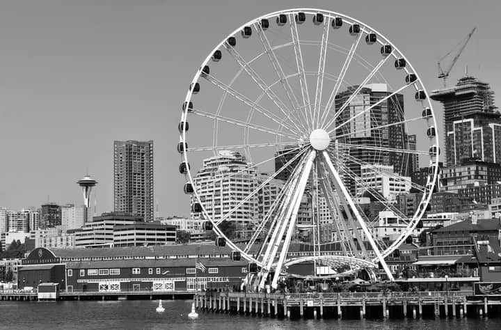 Black and white view of Seattle's Great Wheel and city skyline featuring iconic landmarks.