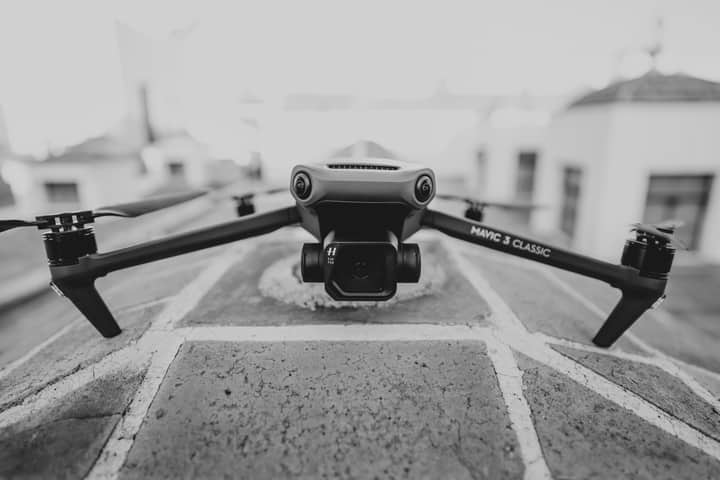 Monochrome image of a Mavic 3 Classic drone positioned on a rooftop, captured up close.