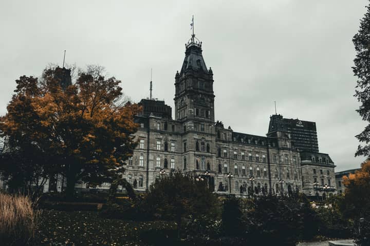 A stunning view of the Quebec City Parliament Building surrounded by autumn foliage.