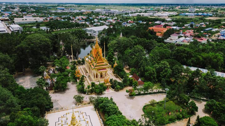 Stunning aerial shot of Wat Phnom temple in lush green Phnom Penh landscape.