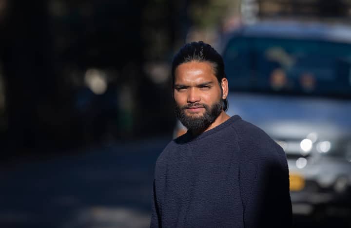 Portrait of a bearded man standing outdoors in Kolkata, India, with natural lighting.