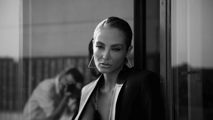 Elegant black and white portrait of a woman posing with striking geometric earrings.