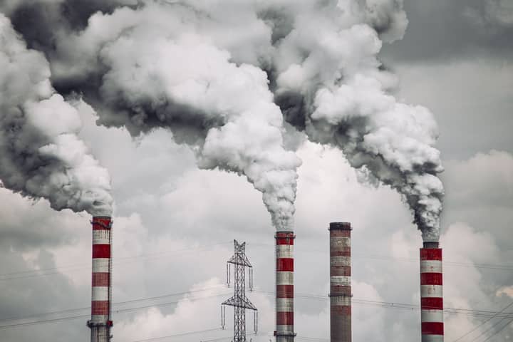 Smoke billows from factory chimneys in Konin, Poland, highlighting pollution and environmental impact.
