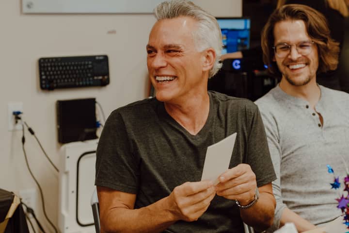Two smiling coworkers enjoying a light moment in an office environment.
