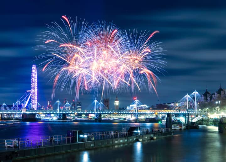 Beautiful fireworks display illuminating the London skyline at night over the Thames River.