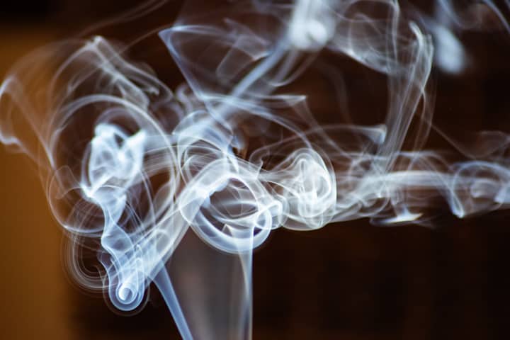 Intricate patterns of swirling smoke against a dark background, capturing movement and texture.