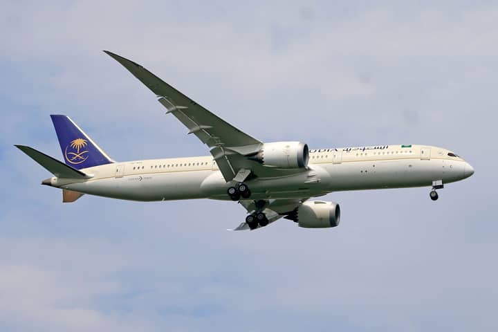 Saudia Airlines Boeing 787 aircraft captured during flight with clear sky background.
