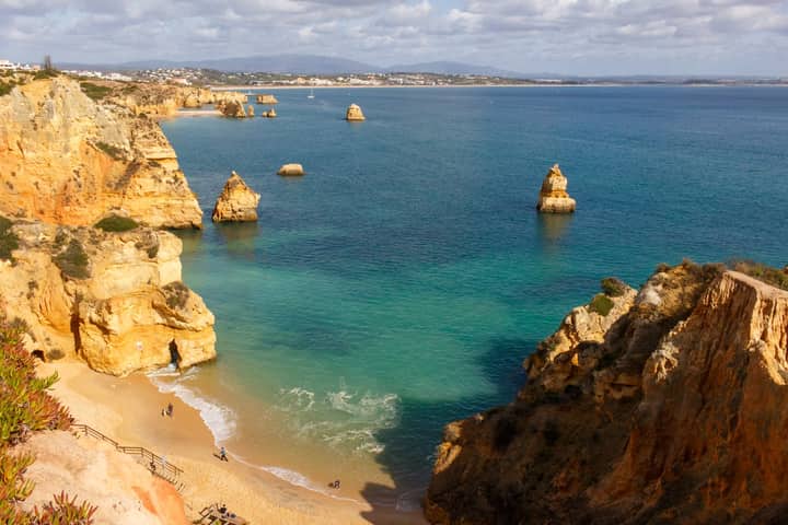 Beautiful aerial view of Praia do Camilo, Lagos, with golden cliffs and turquoise waters in Algarve, Portugal.