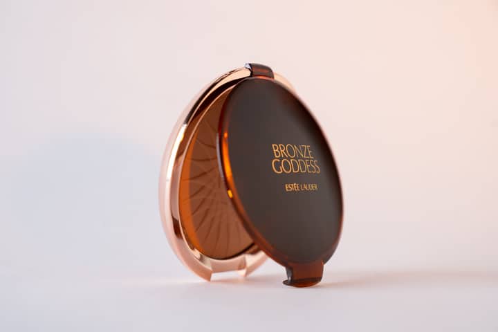 Estee Lauder's Bronze Goddess compact showcased on a clean white background, perfect for beauty-themed collections.