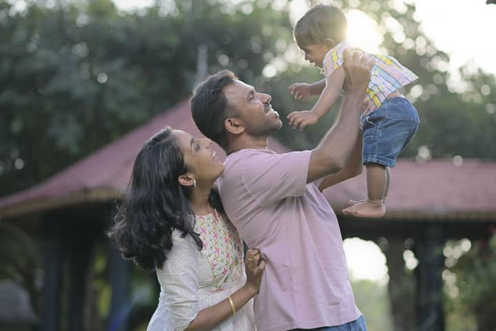 Happy family enjoying time together in a sunlit park, capturing love and joy.