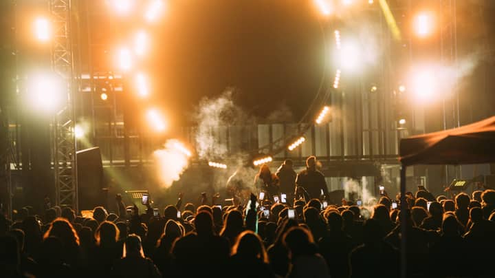 Captivating live concert scene with crowd and bright stage lights at night.