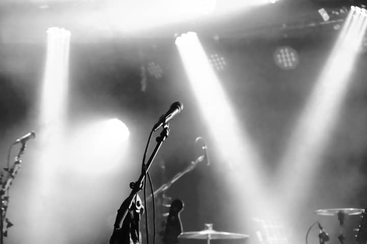 Eerie black and white stage setup with microphones and spotlights ready for a concert.