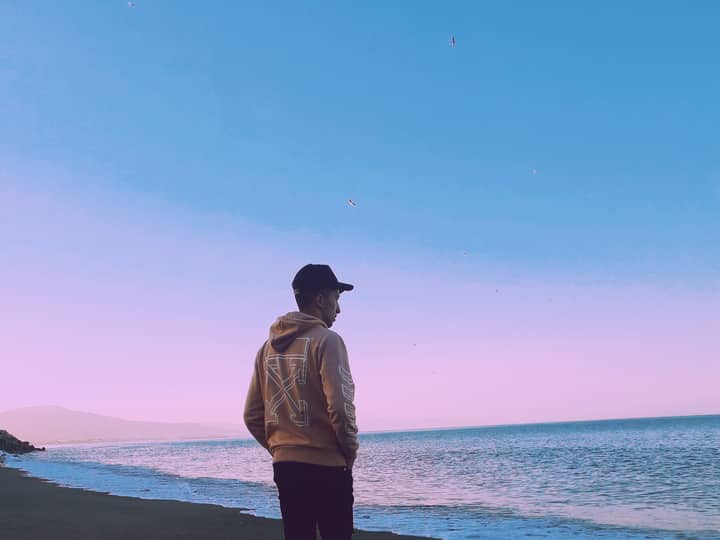 Person enjoying a calm twilight walk along the beach in M'diq, Morocco.