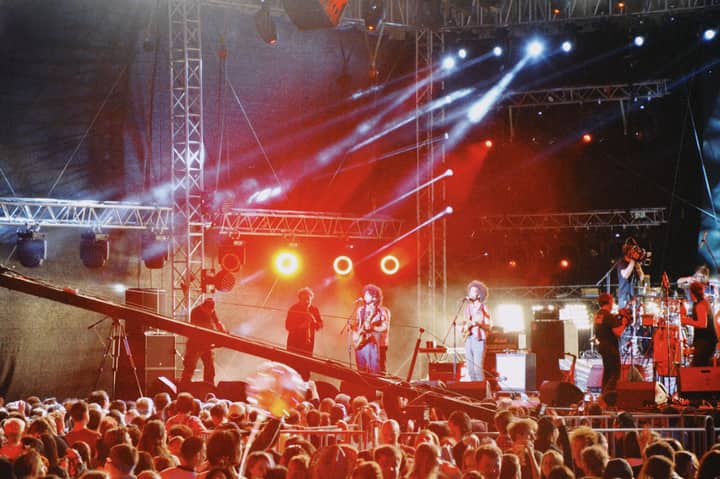 Energetic live concert at night in Almaty with vibrant lights and performing musicians on stage.